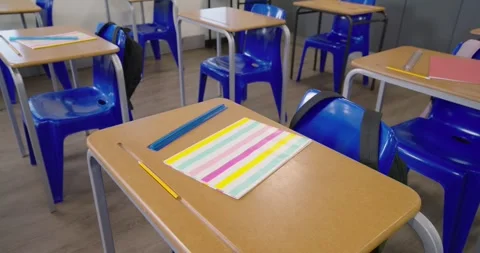 Camera starting to drift right, bringing classroom desk with notebook, pencil Stock Footage 340631334
