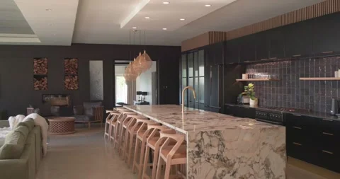 Camera starting near table, panning left and showing marble island, bar stools Stock Footage 336609588