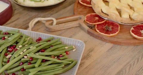 Camera is starting to pan right and up, revealing green beans and pie to show Stock Footage 345607386