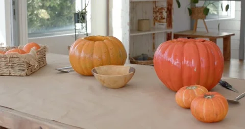 Camera is starting to pan right revealing pumpkin cluster on table to showcase Stock Footage 346709330