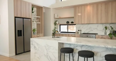 Camera is starting wide and panning across marble kitchen island, revealing sink Stock Footage 337238291