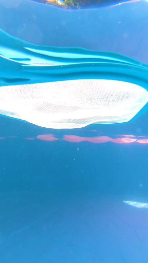 Camera submerges to reveal a pool cleaning net underwater Stock Footage 337958425