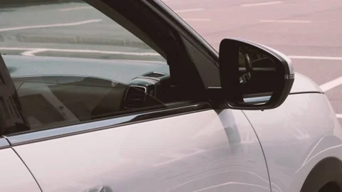 The camera swept across the side and rearview mirror of a white Citroen C5 Stock Footage 157532247