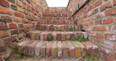 Camera swiftly ascends a narrow staircase within the red brick fortress wall Stock Footage 270405055