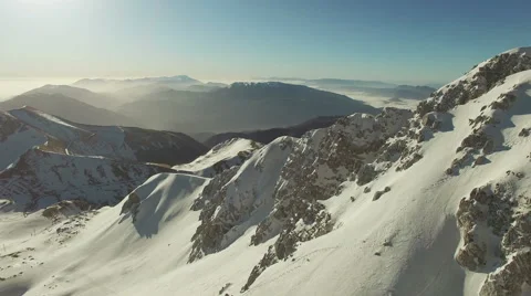 The camera switches close to the snowy mountains. The camera goes forward. N. Stock Footage 63356979