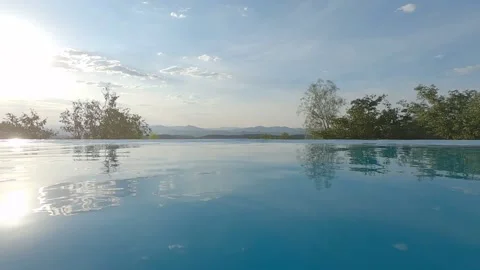 Camera takes a dip into the water from the edge of an infinity pool. Video stock 183076838
