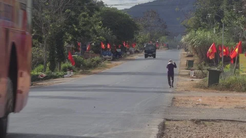 The camera takes a passing bus, a car and a Vietnamese woman walks Stock Footage 123425938