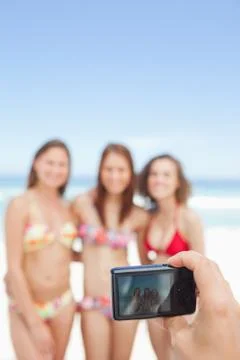 Camera taking a photo of three posing girls Photos