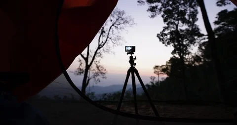 Camera taking a sunrise shot at camping site : time lapse shot shooting from Stock Footage 85847201