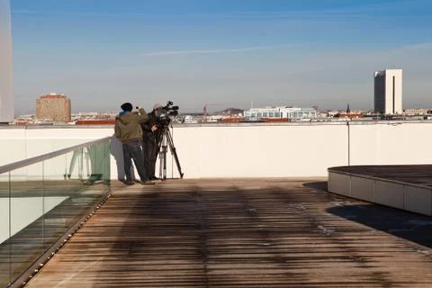 Camera team at work on a rooftop capturing the city Stock Photos