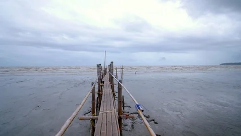 Camera through bamboo bridge toward muddy sea Stock Footage 91518019