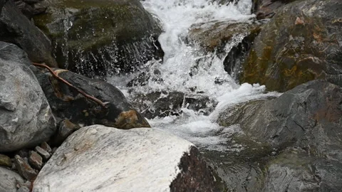 Camera tilt down cascading whitewater mountain waterfall through rocky gully Video stock 234732489