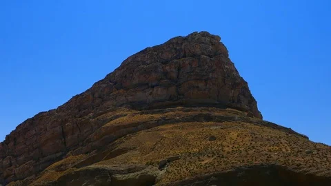 Camera tilt down from a rock hill to crystal salt rock salty beach shore Stock Footage 70355372