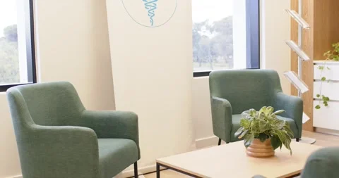 Camera tilting and panning, revealing clinic seating with table pot and banner Stock Footage 336844640