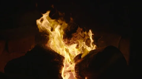 Camera tilting down onto campfire flames in slow motion. Stock Footage 98841798