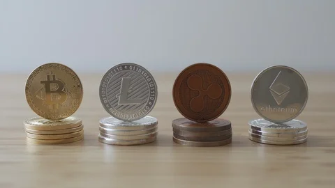 Camera tilting down to four piles of crypto currency coins Video stock 85743915