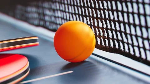 The camera is tilting up a table tennis ball. Ping pong ball, paddles and net. Video stock 133438001