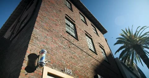 Camera is tilting upward from lower-left, revealing three-story brick facade Stock Footage 335747784