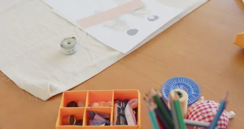 Camera is tilting upward revealing orange organizer and notions on table to show Stock Footage 344964642