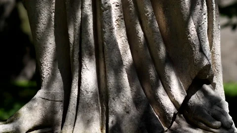 Camera Tilts Up an Ancient Statue Standing in Sunlight under Garden Trees 4K Stock Footage 200974805