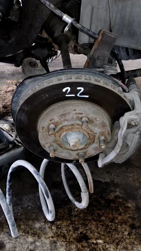 Camera tilts down to reveal a rusty car brake assembly Stock Footage 335835474