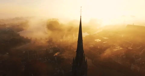 Camera tilts down showing a cross on top of a Christian church covered in fog Video stock 63615911