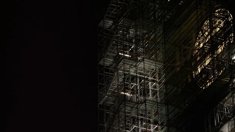 Camera tilts up a high series of scaffolding along a clock tower Video stock 84008650