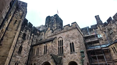 Camera tilts up inside Alnwick Castle courtyard, revealing tall stone walls Stock Footage 340357067