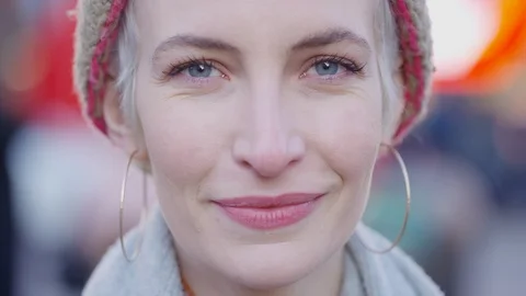 Camera tilts up on this portrait of young pretty female smiling to camera as she Video stock 122233654