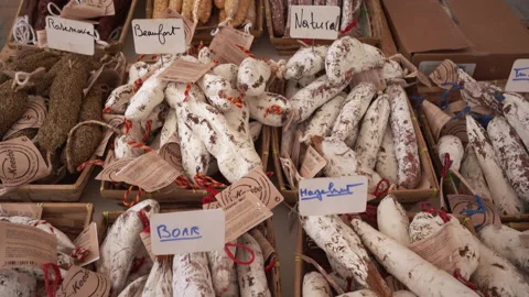 Camera tilts up revealing different types of labelled French sausages at a stall Stock Footage 150399349