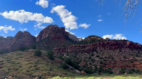 Camera tilts up revealing majestic cliffs in zion national park under scattered Stock-Footage 305567882