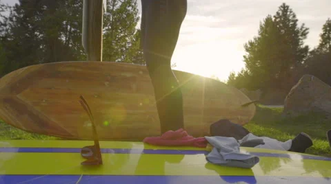Camera tilts to show man getting ready to paddleboard Stock Footage 62842135