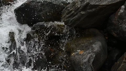 Camera tilts up a terraced rocky mountain waterfall with whitewater Video stock 234739376