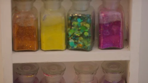 Camera tilts up various bottles of artistic materials of colours and shapes Video stock 112081176