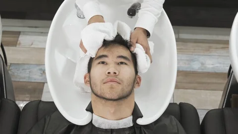 Camera top view Asian man's hairdresser washes the client's head Stockbeeldmateriaal 116962917