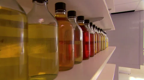 Camera Track Past Bottles Towards Scientist In Laboratory Stock Footage 40623420