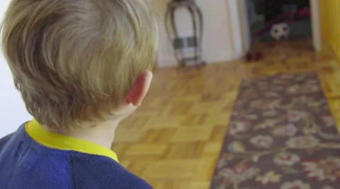 Camera tracking from behind, cute kid runs down hallway Stock Footage 64644981