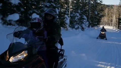 Camera is tracking father driving skimobile together with daughter Stock Footage 110904791