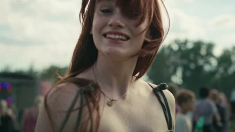 Camera tracking ginger haired smiling young caucasian woman at music festival Stock-Footage 202115727