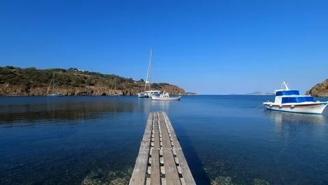 Camera tracks along a jetty towards boats and the ocean 動画素材 91992679