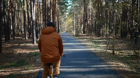 Camera tracks happy couple as they cycle along track smiling and have fun Video stock 65467677