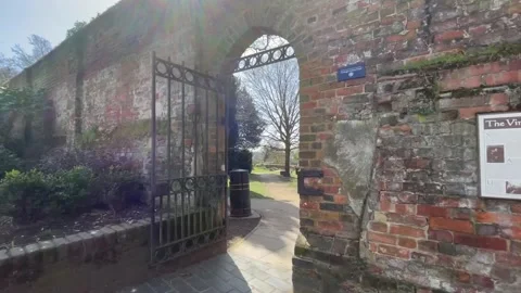 Camera tracks through gate into a walled garden to reveal the Cathedral 스톡 동영상 151460922