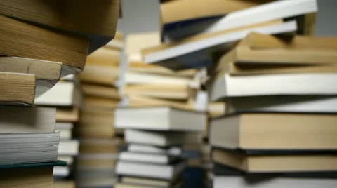 Camera tracks through teetering piles of books. Video stock 12035734