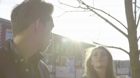 Camera tracks with two models as they walk down a sidewalk Stock Footage 61575207