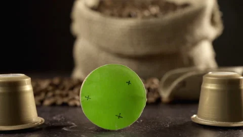 Camera travels over table with coffe beans, golden coffee capsules, a coffe bag Stock-Footage 138734726