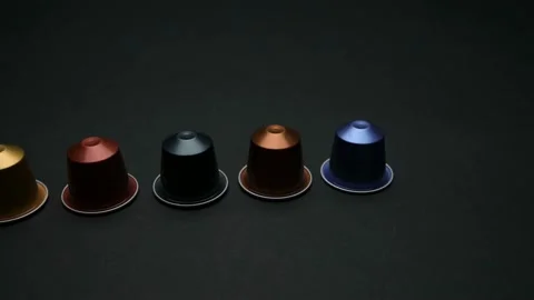 Camera travels over table with coloured expresso coffee capsules, a coffee bag Stock Footage 177077535
