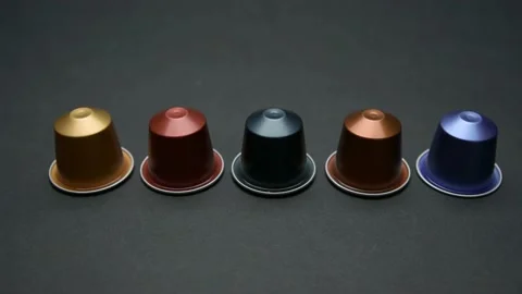 Camera travels over table with coloured expresso coffee capsules Stock Footage 197563493