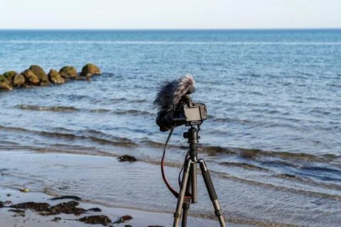 A camera is on a tripod on a beach Stock Photos