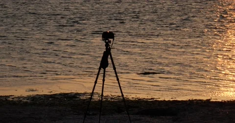 Camera on a tripod at the beach at sunset Stock Footage 150198557