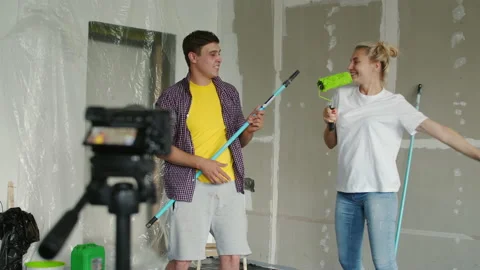 A camera on a tripod captures a guy and a girl having fun and dancing during the Stock Footage 135942104